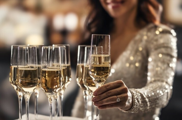 A person taking a glass of sparkling wine at a standing dinner at ABBA The Museum.