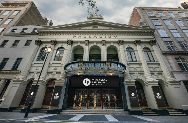 Front entrance of London Palladium theater, showcasing it's classical design with columns, arches, and ornate details.