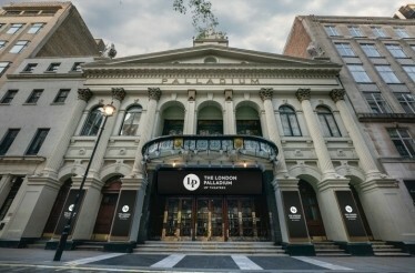 Front entrance of London Palladium theater, showcasing it's classical design with columns, arches, and ornate details.