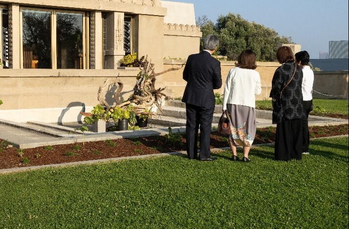 Group of visitors touring around the outdoor of Frank Lloyd Wright's iconic Hollyhock House.