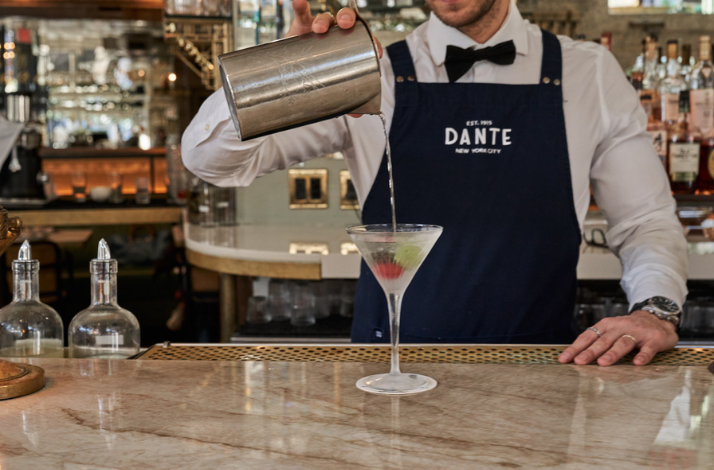 Bartender pouring a drink at the iconic Caffe Dante.